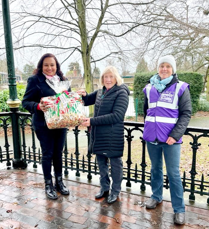 Donating a Malaysian artisan-made bag to the winner of the Malvern Priory Park photo competition in Malvern, Worcestershire